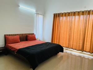 Schlafzimmer mit einem Bett mit orangefarbenen Vorhängen in der Unterkunft Luxurious homes lavasa in Lavasa