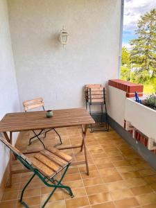 eine Terrasse mit einem Holztisch und Stühlen auf dem Balkon in der Unterkunft Appartment Weitblick in Eisenstadt