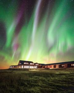 een gebouw met het noorderlicht in de lucht bij Hotel Rangá in Hella