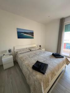 um quarto com uma cama grande e 2 toalhas pretas em Simo and Manu's little home em Cagliari