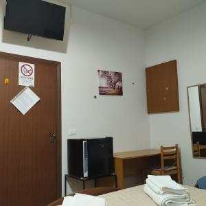 a room with a bed and a tv on the wall at La Casetta Di Cotignola in Cotignola