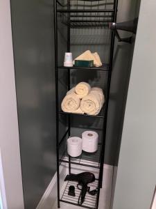 a black shelf with toilet paper and a phone at Rose & Thistle B&B Lunenburg in Lunenburg