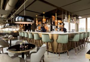 een bar in een restaurant met stoelen en tafels bij NH Collection Eindhoven Centre in Eindhoven