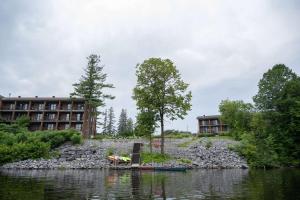 eine steinerne Mauer neben einem Fluss mit Gebäuden in der Unterkunft Ramada by Wyndham Ottawa On The Rideau in Ottawa