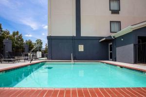 uma piscina em frente a um edifício em Days Inn by Wyndham Baton Rouge I-10 em Baton Rouge