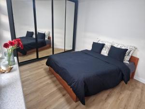 1 dormitorio con 2 camas y un espejo grande en Apartament w centrum, en Kętrzyn