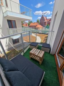 balcón con sofá y banco en el césped en Apartament w centrum, en Kętrzyn