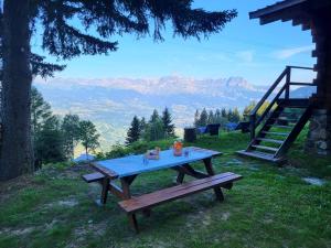 uma mesa de piquenique numa colina com vista para as montanhas em Chalet d'alpage avec vue incroyable em Saint-Gervais-les-Bains