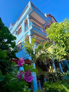 un edificio azul con plantas delante en Ocean Breeze Inn en Boracay