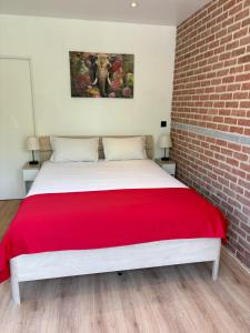 a bedroom with a large bed with a red blanket at Flat vane & Soun in Waterloo