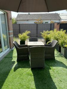 a table and chairs on the grass with an umbrella at Flat vane & Soun in Waterloo