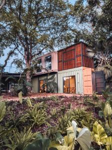 een huis op een heuvel met bomen en planten bij OBOĒ Gardenstē in Pereybere