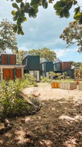 een groep huizen met bomen op de achtergrond bij OBOĒ Gardenstē in Pereybere