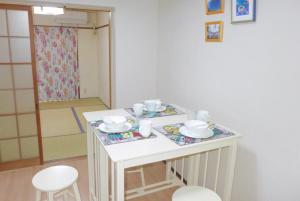 mały biały stół z kubkami i talerzami w obiekcie Aoisora Aoiumi no guest house - Vacation STAY 74840v w mieście Takamatsu