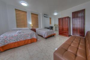 a bedroom with two beds and a couch at Galapagos Dreams in Puerto Ayora