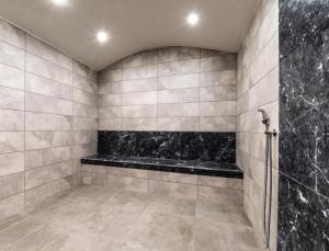 baño con banco negro y ducha en Хотел Релакс, en Kazanlak