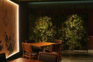 une salle à manger avec un mur vert, une table et des chaises dans l'établissement Eikon Apartments Abastumani, à Abastumani