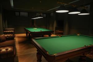 une salle de billard avec deux billards et une chaise dans l'établissement Eikon Apartments Abastumani, à Abastumani