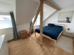 een slaapkamer met een bed met een blauw dekbed bij MiniLoft Andernach in Andernach