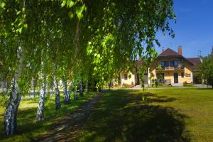 a house with a row of trees in the yard at Crystal Apartman in Mórahalom