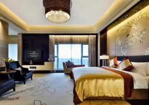 a bedroom with a large bed and a television at Crowne Plaza Chengdu Panda Garden, an IHG Hotel in Chengdu