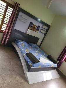 um quarto com uma cama com um edredão azul em The Grassland homestay em Chikmagalūr