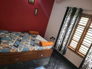 una camera con letto e finestra di The Grassland homestay a Chikmagalūr