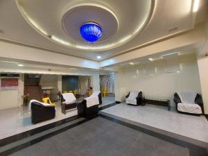 una sala d'attesa con sedie e soffitto blu di Super Hotel O Happy Homely Stay Near Pune Airport a Khadki