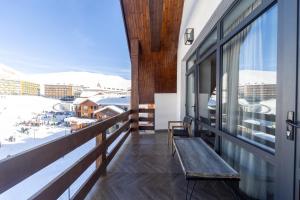 a balcony with a view of the snow covered mountains at PENTHOUSE BY GONDOLA 50 Meters, New Gudauri Suites in Gudauri