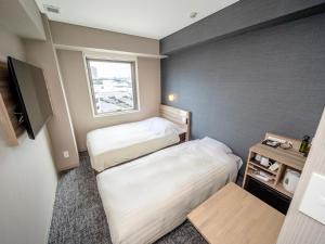 A bed or beds in a room at Super Hotel Sendaieki Higashiguchi Tennenonsen