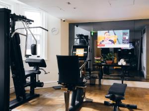 Zimmer mit einem Friseursalon mit Stühlen und einem TV in der Unterkunft The Adria in London