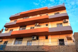 - un grand bâtiment orange avec balcon dans l'établissement Luxor View Hostel, à Louxor