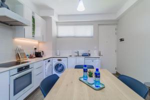 a kitchen with a wooden table and blue chairs at STAY Menlyn in Pretoria