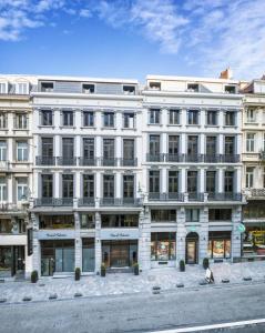 un grande edificio bianco sul lato di una strada di Hotel Hubert Grand Place a Bruxelles