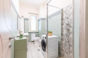 a bathroom with a washer and dryer next to a toilet at Hostly- Don Bosco Light Lodge in Rome