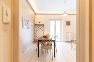 a dining room with a table with a bowl of fruit on it at Hostly- Don Bosco Light Lodge in Rome