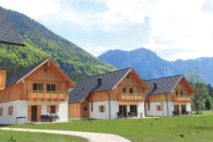 un groupe de bâtiments avec des montagnes en arrière-plan dans l'établissement Holiday Homes Obertraun/Oberösterreich 86, à Obertraun