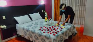 une femme faisant un lit avec un bouquet de petits gâteaux dans l'établissement Hotel CASA REAL, à Tacna