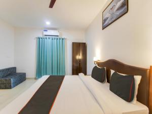 a bedroom with a bed and a blue curtain at home and beyond by myroom in Goa