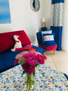 eine Vase mit Blumen auf einem Tisch im Wohnzimmer in der Unterkunft Apartament Gęsie Piórko in Jastrzębia Góra