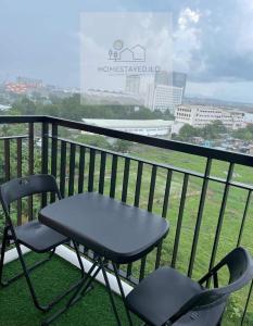 une table et deux chaises assises sur un balcon dans l'établissement Homestayed ilo, à Iloilo