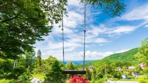 een schommel in een park met bergen op de achtergrond bij Mogamitakayu Zenshichinoyu Ohira in Zao Onsen