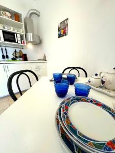 una cocina con una mesa con tazones azules. en Rosa's House - zona ospedaliera, en Cagliari