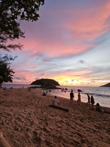 - un groupe de personnes sur une plage au coucher du soleil dans l'établissement Good vibes bungalow at Ya Nui beach, à Phuket