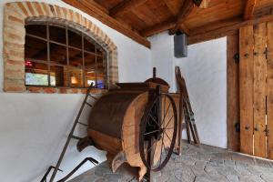 a wooden wine wheel in a room with a window at Hotel Stara Skola in Sloup