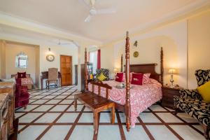 - une chambre avec un lit, une table et un canapé dans l'établissement Dera Rawatsar - Heritage Hotel, à Jaipur