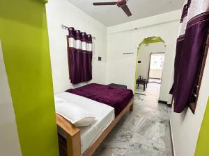 ein Schlafzimmer mit einem Bett und einem Spiegel in einem Zimmer in der Unterkunft The Kaya group stay Srirangam in Srīrangam