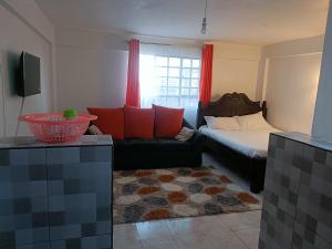 a living room with a couch and a bed at Befil in Meru