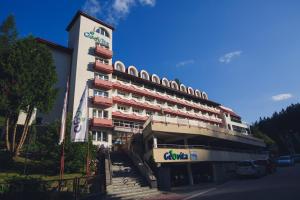 un bâtiment avec un panneau sur son côté dans l'établissement Geovita Krynica-Zdroj, à Krynica-Zdrój