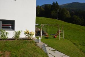 une cour avec une balançoire installée dans l'herbe dans l'établissement Appartement Wieshof, à Neukirchen am Großvenediger